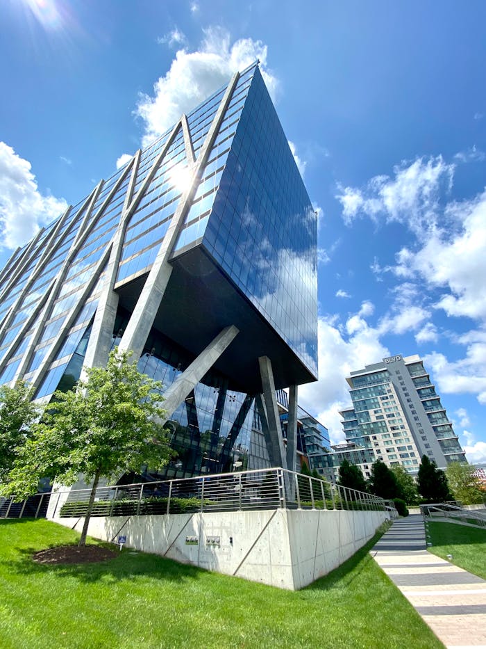 A sleek modern office building with glass facade, captured under a bright blue sky.