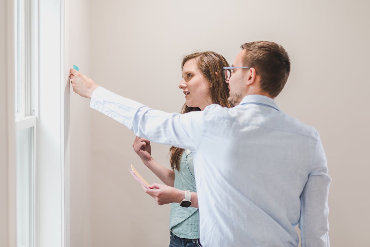 Young professionals collaborating and brainstorming with sticky notes on a wall.